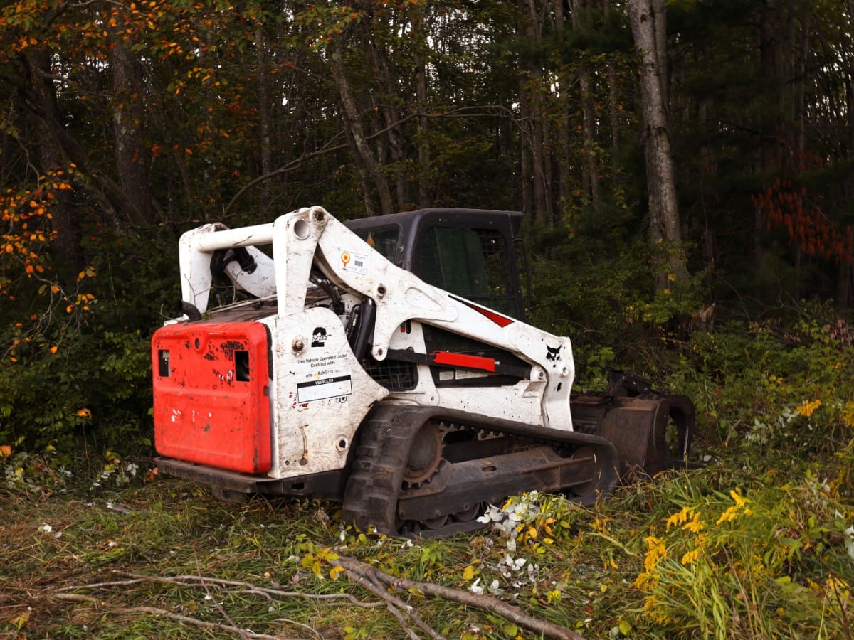 Forestry mulcher head on a track loader chewing through brush