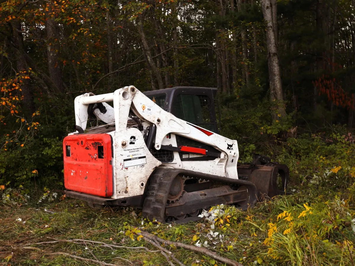 Forestry mulcher head on a track loader chewing through brush